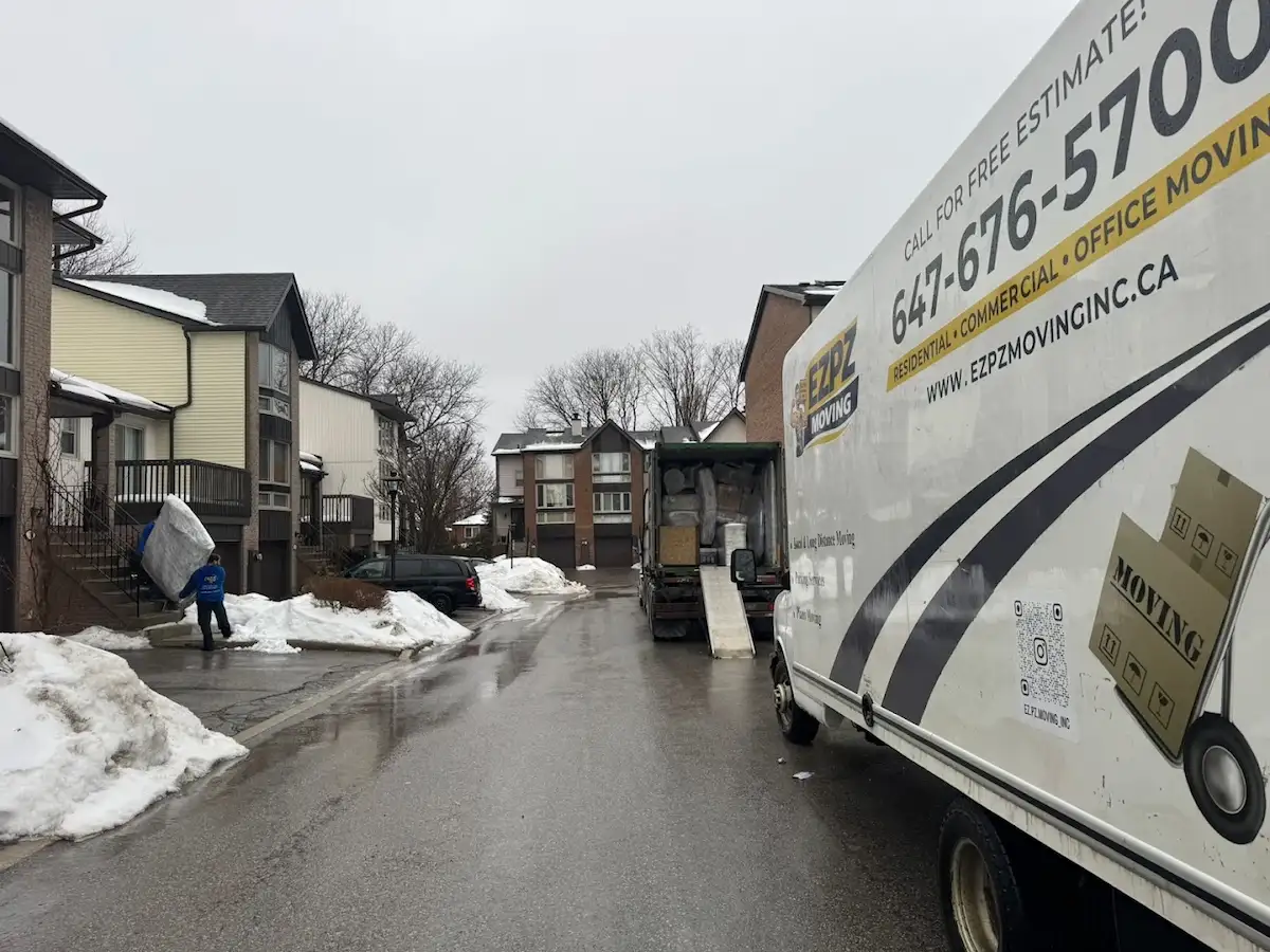 Professional residential movers carrying furniture into a family home in North York